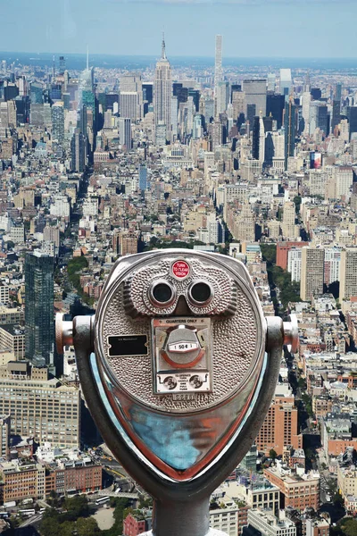 Wrzut monety lornetki na szczycie skały, przeciwko Imperium stan budynku Manhattan, Nyc — Zdjęcie stockowe