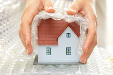Eller kadın kabarcık şal evi koruma veya sigorta kavramı ile bir model ev kapsayan