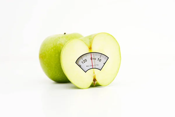 Mezza mela con display scala di peso all'interno, suggerendo una dieta sana per perdere peso — Foto Stock