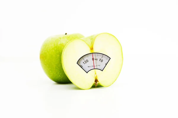 Mezza mela con display scala di peso all'interno, suggerendo una dieta sana per perdere peso — Foto Stock