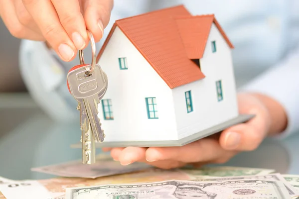 Konieczności zakupu koncepcja domu kobieta rękami trzymając modelu Dom i klucze — Zdjęcie stockowe