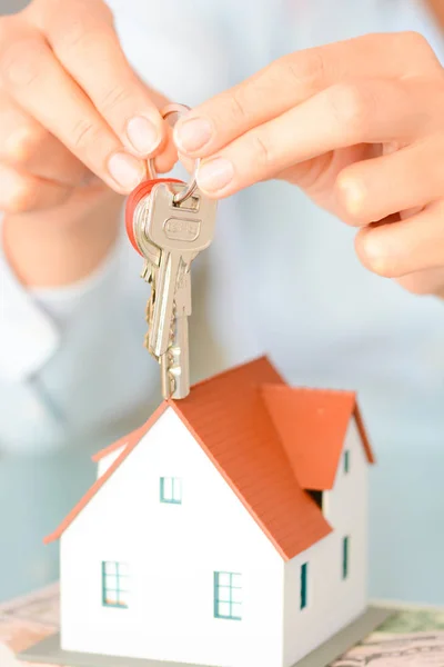Покупка концепции дома с женщиной в руках, держащей образцовый дом и ключи — стоковое фото