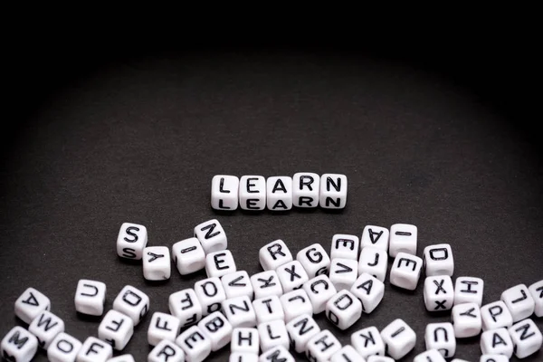 Learn word spelled with white beads on black background — Stock Photo, Image