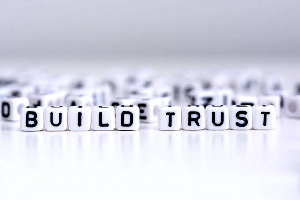 Construir conceito de processo de confiança com letras ladrilhadas em fundo branco — Fotografia de Stock