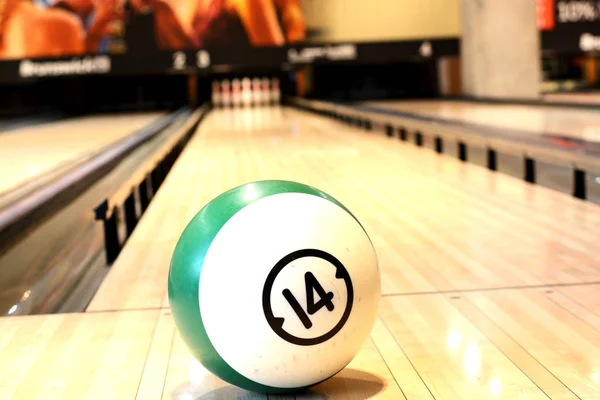 Conceito de jogo com bola no chão de madeira de boliche contra dez pinos — Fotografia de Stock