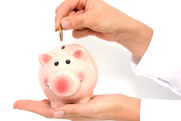 Woman hand putting money in a pink piggy bank — Stock Photo, Image