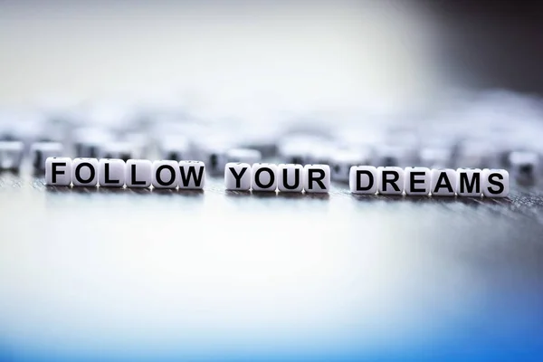 Follow your dreams text made from plastic letter beads — Stock Photo, Image