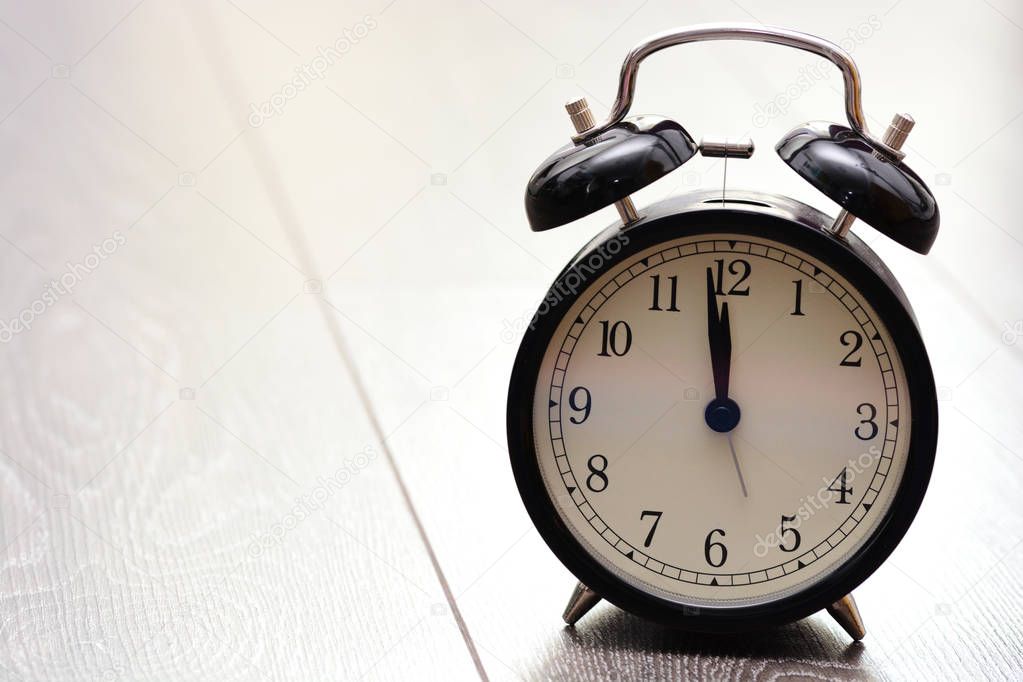 Retro bell alarm clock on wooden background