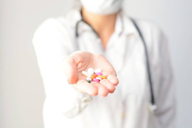Cropped shot of a female doctor displaying a handful of tablets and pills in her palm clipart