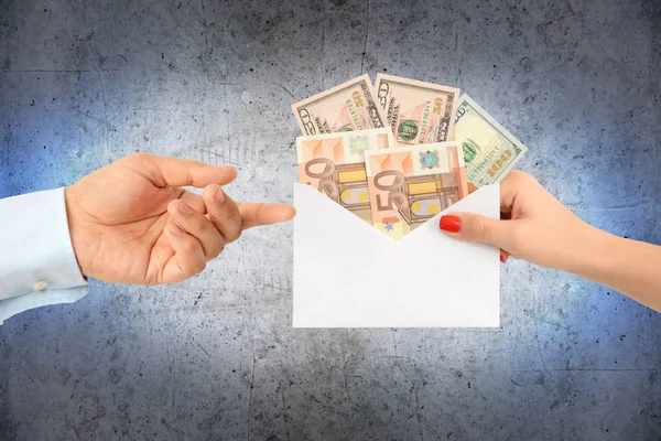 Женщина подкупает мужчину конвертом, полным денег — стоковое фото