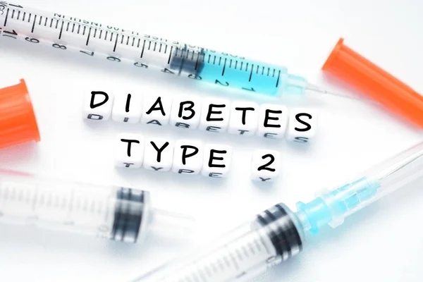 类型 2 型糖尿病文本拼写与塑料封信珠放在旁边的胰岛素注射器 — 图库照片