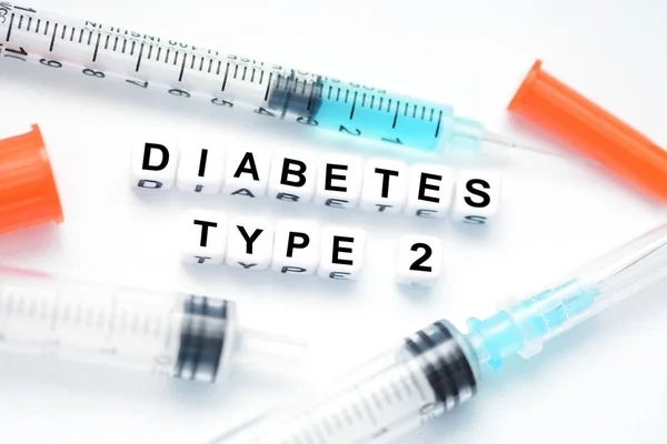 Texto de diabetes tipo 2 escrito con abalorios de plástico colocados junto a una jeringa de insulina —  Fotos de Stock