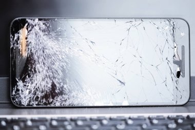 Kırık ekran ile smartphone cep telefonu tamir hizmetleri düşündüren laptop klavye üzerinde yer  