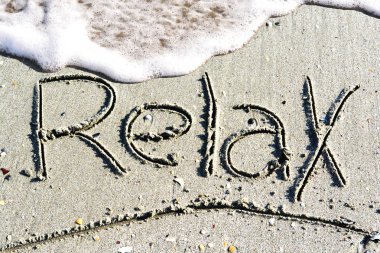 Kum deniz kenarında üzerinde el yazısı kelime sakin ol