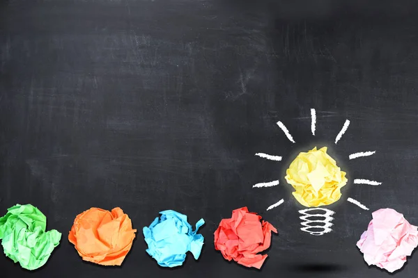 Bright idea concept with light bulb shaped crumpled paper on blackboard — Stock Photo, Image