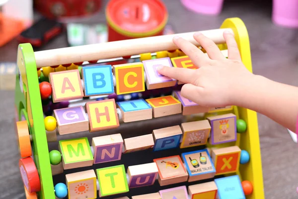 Main d'enfant jouant avec un jouet éducatif — Photo