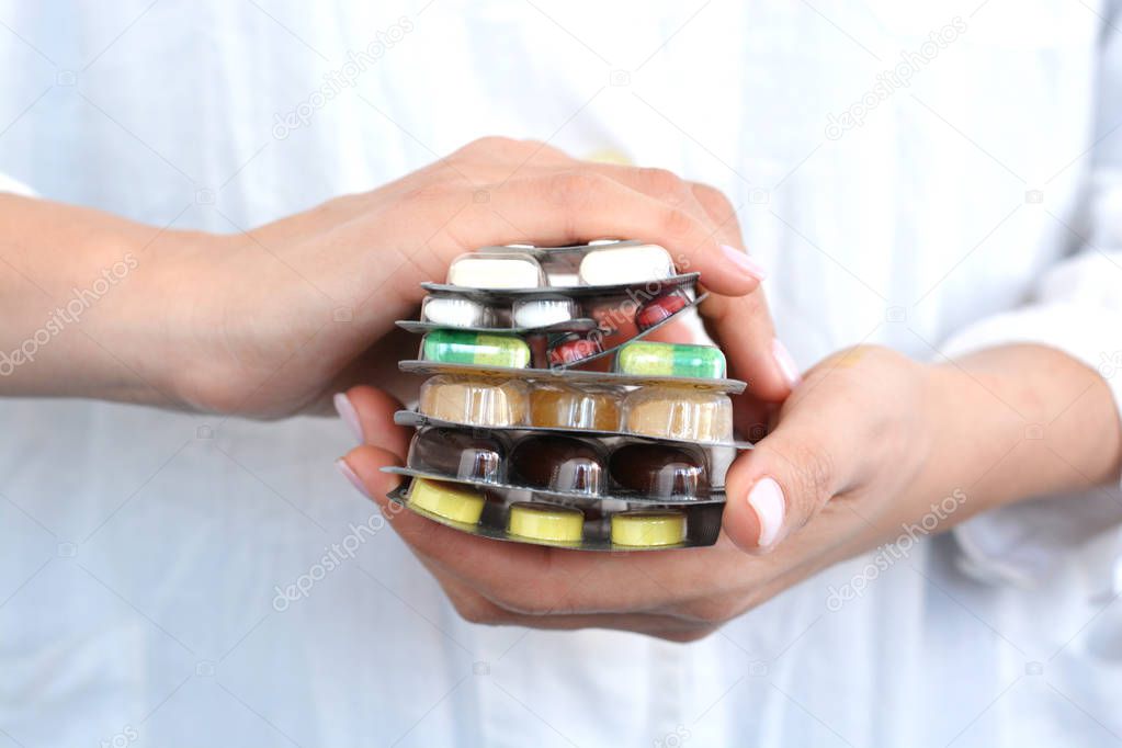 Woman holding a stack of pills blisters in her hands