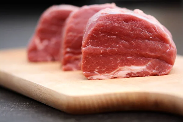 Sabrosa carne cruda de ternera o carne de res en tabla de cortar de madera —  Fotos de Stock