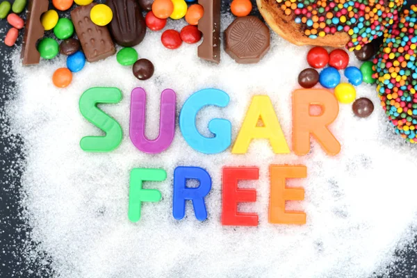 Conceito de saúde com blocos de letras multicoloridas em açúcar branco granulado sem açúcar ortográfico — Fotografia de Stock