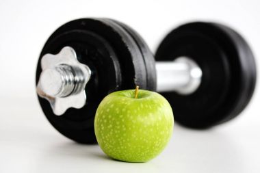 Fitness kavramı ile sağlıklı gıda düşündüren ve diyet egzersiz Halter ve yeşil elma