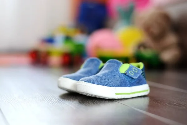 Сині крихітні туфлі на дерев'яній підлозі — стокове фото