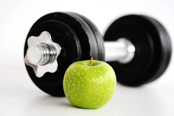 Concetto di fitness con manubri e mela verde che suggeriscono cibo sano ed esercizio fisico nella dieta — Foto Stock