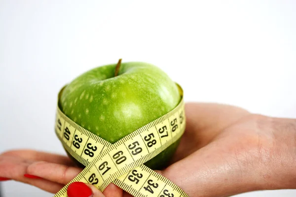 Yeşil elma tutarak ve teyp ölçme kadın el ile diyet kavramı — Stok fotoğraf