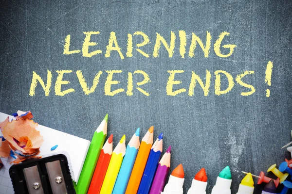 Learning never ends text on blackboard with office tools — Stock Photo, Image