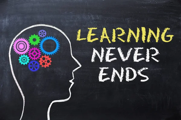 Learning never ends message  on blackboard with human head shape and gears — Stock Photo, Image