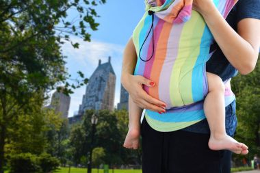 Genç anne taşıma yürümeye başlayan çocuk Ssc Central Park, New York City'deki yumuşak yapılandırılmış taşıyıcıya Babywearing konseptiyle