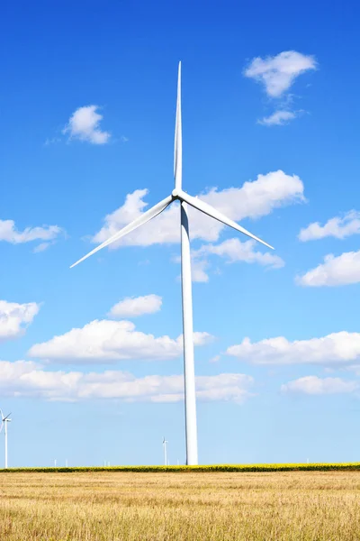 Turbina eólica que produce energía alternativa con un cielo azul claro —  Fotos de Stock