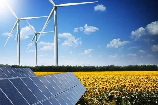 Conceito de energia verde com painéis solares e turbinas eólicas em um campo de girassol — Fotografia de Stock