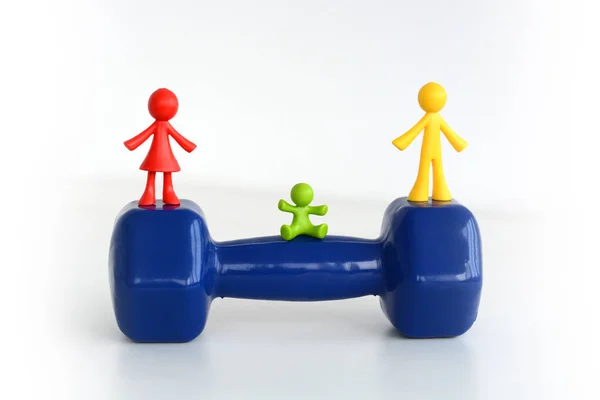 Family team concept with human miniature on dumbbell — Stock Photo, Image