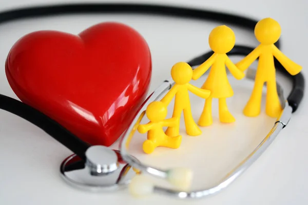 Conceito de saúde da família com brinquedos de plástico, coração vermelho e estetoscópio sobre fundo branco — Fotografia de Stock