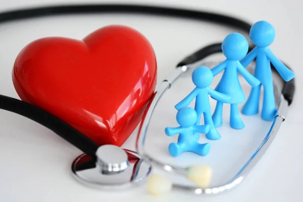 Familie gezondheidszorg concept met plastic speelgoed, rood hart en stethoscoop op witte achtergrond — Stockfoto