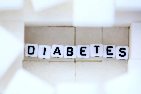 Concepto de enfermedad de la diabetes con azúcar blanco cúbico como fondo — Foto de Stock