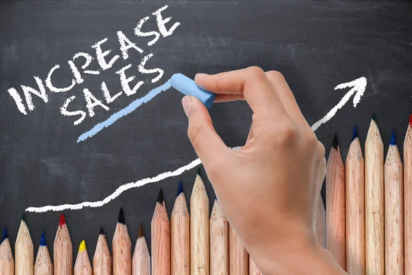 Sales increase concept or target on chalkboard with wave of colored pencils — Stock Photo, Image