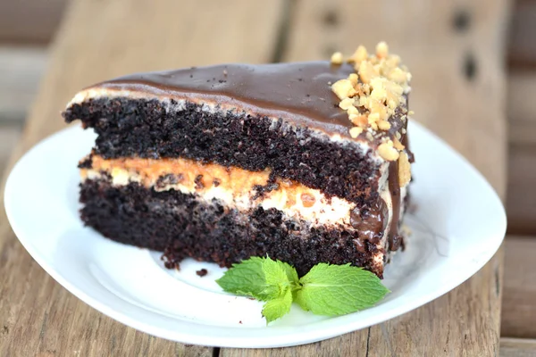 Pastel de chocolate con almendras y toffee en mesa de madera — Foto de Stock