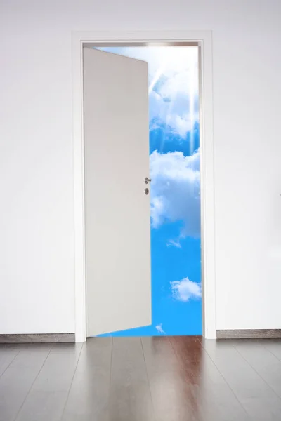 White wall with opened door to new horizons, suggesting a new way in life