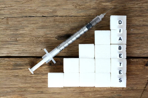 Concepto de diabetes con escaleras hechas de cubitos de azúcar blanco y jeringa de insulina —  Fotos de Stock