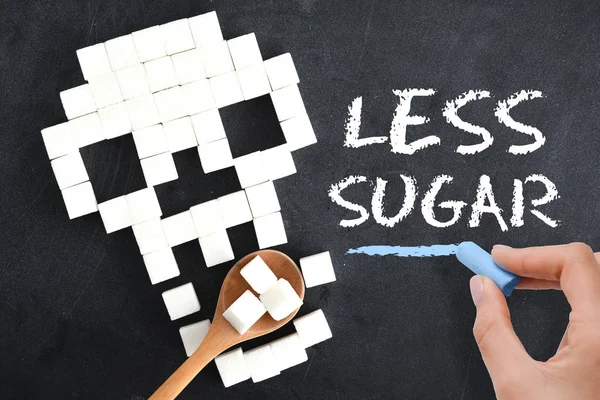 Meno zucchero scritto a mano sulla lavagna vicino alla silhouette del cranio umano che mangia zucchero — Foto Stock