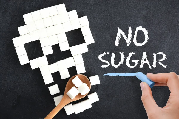 No sugar advice handwritten on blackboard above sugar cubes scale, suggesting diabetes risk — Stock Photo, Image