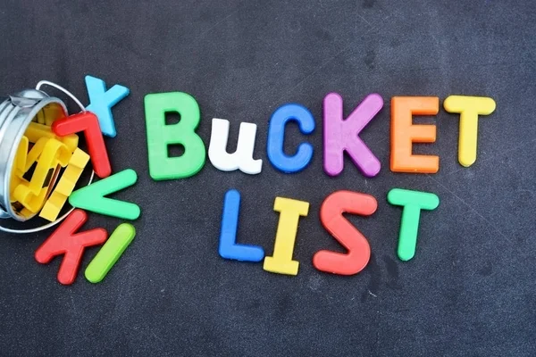 Bucket list concept, things to do in life with iron bucket and magnetic letters on chalkboard — Stock Photo, Image