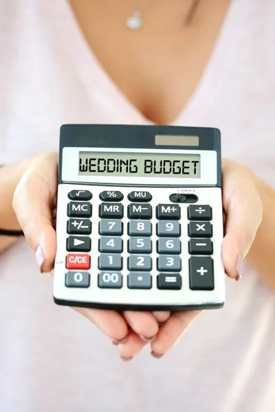 Hochzeitskostenkonzept mit kleinem Taschenrechner in Frauenhand zur Rechtschreibung des Hochzeitsbudgets auf dem Display — Stockfoto