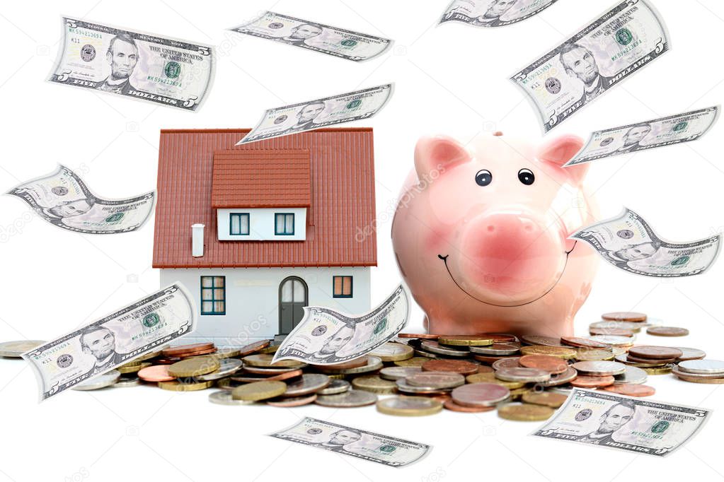 Saving money to buy a house or a property concept with piggy bank and pile of coins and banknotes