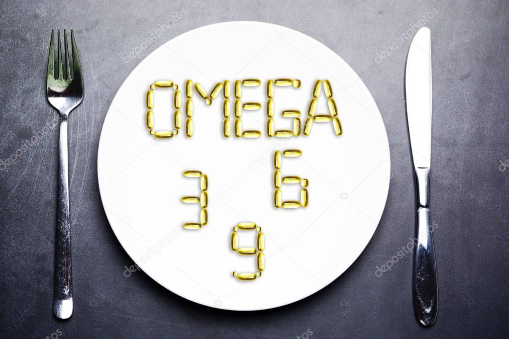 nutritional supplement of omega 3, omega 6 or omega 9 from yellow fish oil capsules on plate
