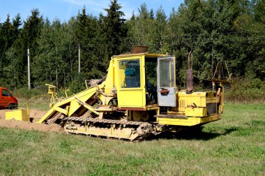 Kazıcı boru döşeme için bir siper kazıyor