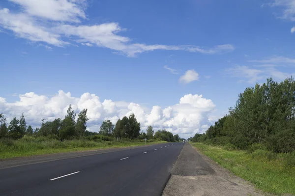 Road in the north of Russia stretches into the distance on a clear summer day — Stock Photo, Image
