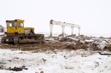 Buldozer eski binayı gömmek için inşaat alanında çalışıyor.