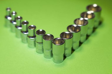 Yeşil bir arka plan üzerinde somun anahtarları kümesi